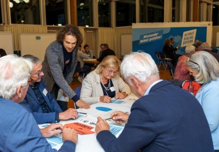 Person, sitzend, hält beschriftetes Schild mit der Beschriftung: Bildung für nachhaltige Entwicklung